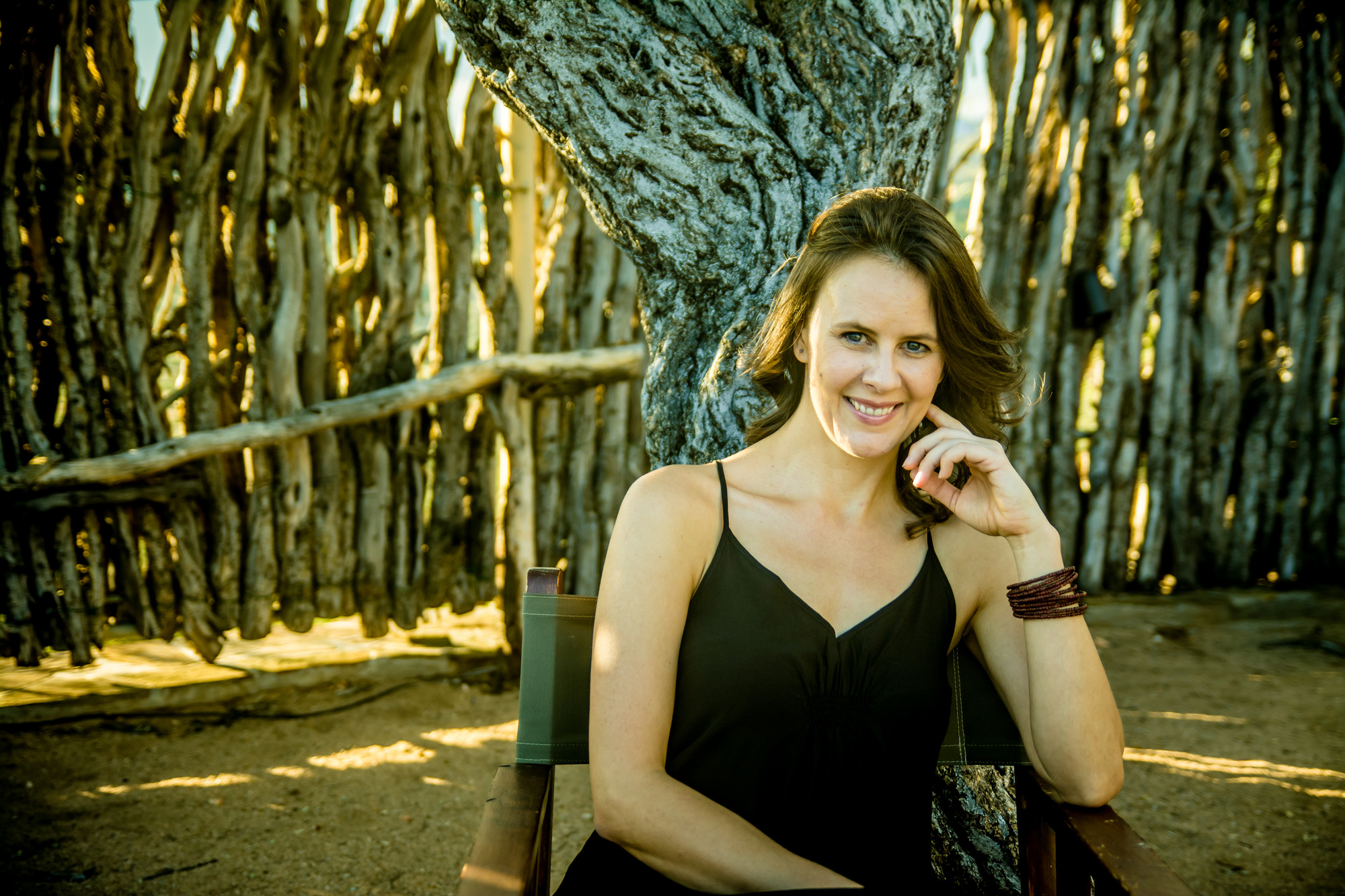 Portrait of Jani Sophia Schneider beside a rustic fence